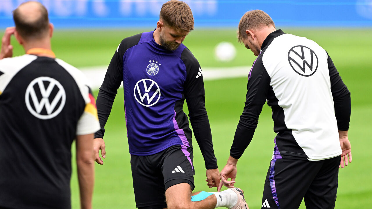 09 September 2024, Netherlands, Amsterdam: Soccer, national team, Nations League, final training session before the match in the Netherlands, Germany's Niclas Füllkrug (M) points to his leg next to national coach Julian Nagelsmann during the final training session in Amsterdam. Füllkrug broke off training. Photo: Federico Gambarini/dpa - IMPORTANT NOTE: In accordance with the regulations of the DFL German Football League and the DFB German Football Association, it is prohibited to utilize or have utilized photographs taken in the stadium and/or of the match in the form of sequential images and/or video-like photo series.