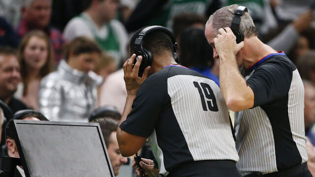 BOSTON - NOVEMBER 27: NBA referees James Capers (19) and Scott Wall look at the replay screen on a blocking call against the Boston Celtics' Jaylen Brown on Brooklyn Nets' Nicolas Claxton during the fourth quarter. After official review, the call was overturned, and Claxton was called for an offensive foul. The Boston Celtics host the Brooklyn Nets in a regular season NBA basketball game at TD Garden in Boston on Nov. 27, 2019.