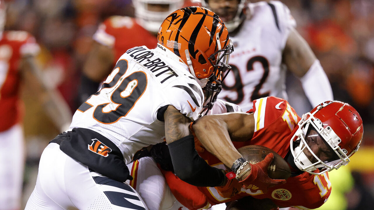 KANSAS CITY, MISSOURI - JANUARY 29: Cam Taylor-Britt #29 of the Cincinnati Bengals tackles Marquez Valdes-Scantling #11 of the Kansas City Chiefs during the third quarter in the AFC Championship Game at GEHA Field at Arrowhead Stadium on January 29, 2023 in Kansas City, Missouri.