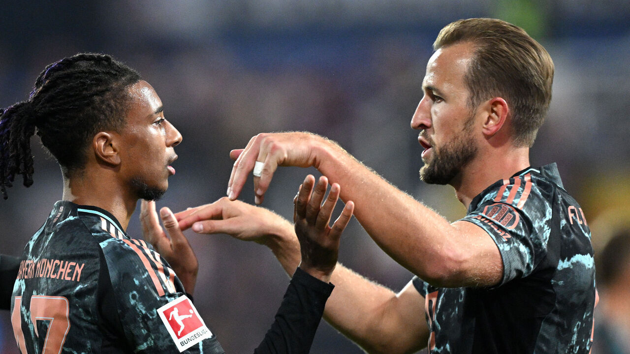KIEL, GERMANY - SEPTEMBER 14: Michael Olise of Bayern Munich celebrates scoring his team's fifth goal with teammate Harry Kane during the Bundesliga match between Holstein Kiel and FC Bayern München at Holstein-Stadion on September 14, 2024 in Kiel, Germany.