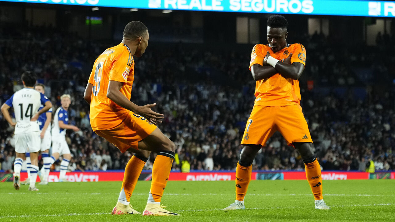 Kylian Mbappe centre-forward of Real Madrid and France celebrates with Vinicius Junior left winger of Real Madrid and Brazil after scoring his sides first goal during the La Liga match between Real Sociedad de Fútbol and Real Madrid CF at Reale Arena on September 15, 2024 in San Sebastian, Spain.