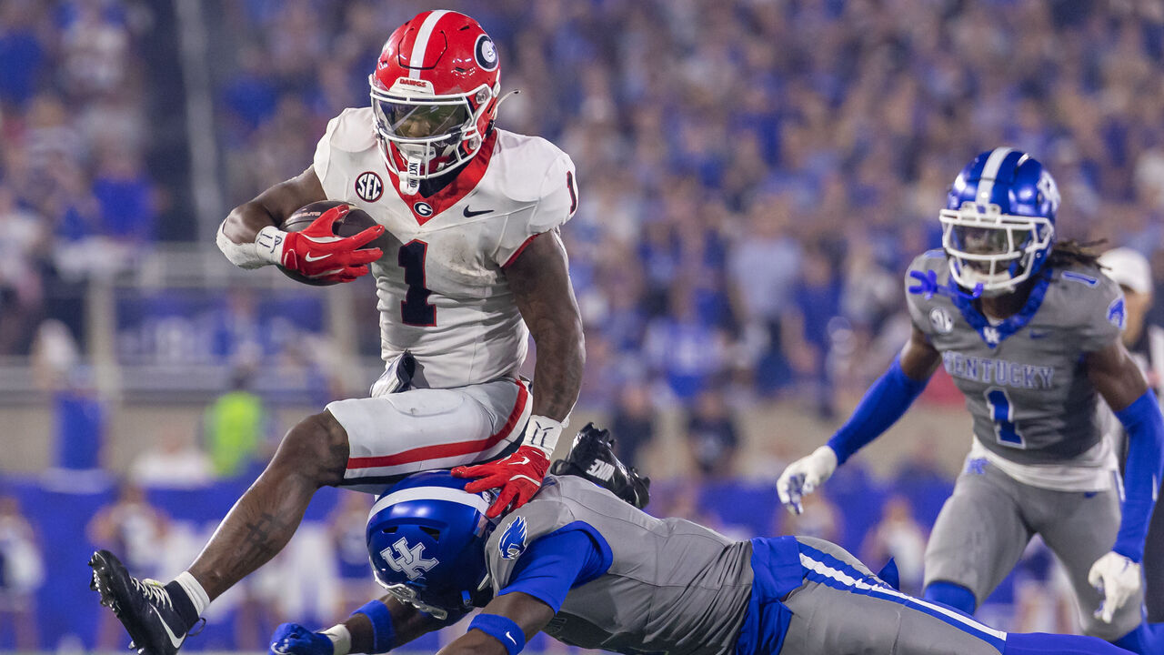 LEXINGTON, KENTUCKY - SEPTEMBER 14: Trevor Etienne #1 of the Georgia Bulldogs leaps to avoid the tackle from Kristian Story #4 of the Kentucky Wildcats during the second half at Kroger Field on September 14, 2024 in Lexington, Kentucky.