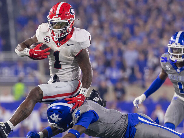 LEXINGTON, KENTUCKY - SEPTEMBER 14: Trevor Etienne #1 of the Georgia Bulldogs leaps to avoid the tackle from Kristian Story #4 of the Kentucky Wildcats during the second half at Kroger Field on September 14, 2024 in Lexington, Kentucky.