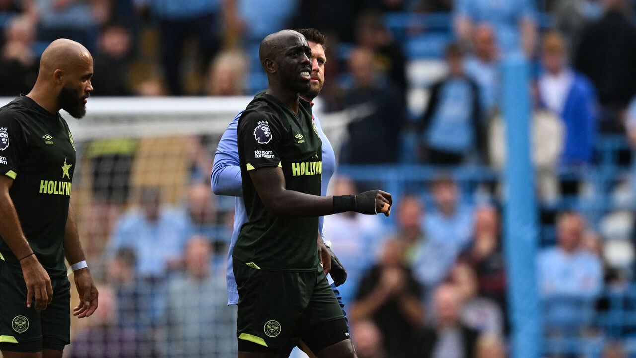 Brentford's French-born DR Congo striker #11 Yoane Wissa (frnt C) is escorted out of the pitch following an injury during the English Premier League football match between Manchester City and Brentford at the Etihad Stadium in Manchester, north west England, on September 14, 2024.
