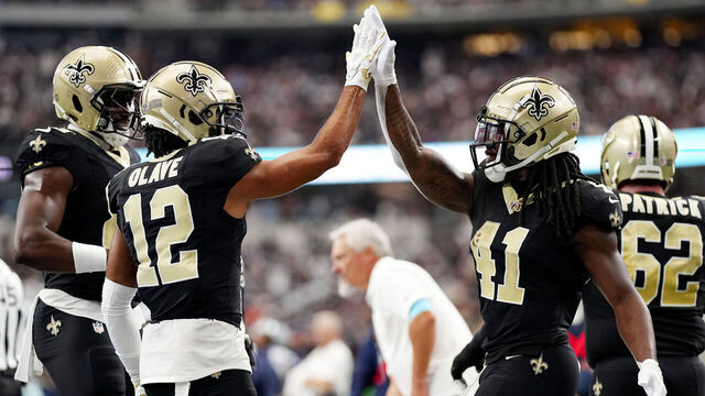 ARLINGTON, TEXAS - SEPTEMBER 15: Alvin Kamara #41 and Chris Olave #12 of the New Orleans Saints celebrate a touchdown during the second quarter at AT&T Stadium on September 15, 2024 in Arlington, Texas.