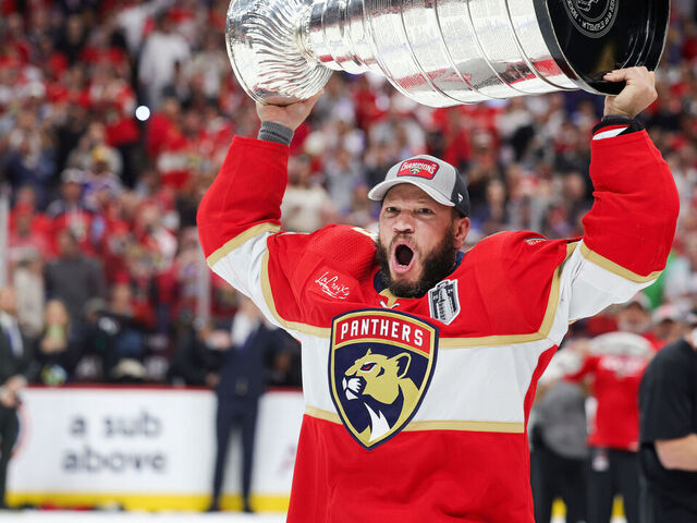 SUNRISE, FLORIDA - JUNE 24: Kyle Okposo #8 of the Florida Panthers hoists the Stanley Cup after Florida's 2-1 victory against the Edmonton Oilers in Game Seven of the 2024 Stanley Cup Final at Amerant Bank Arena on June 24, 2024 in Sunrise, Florida.