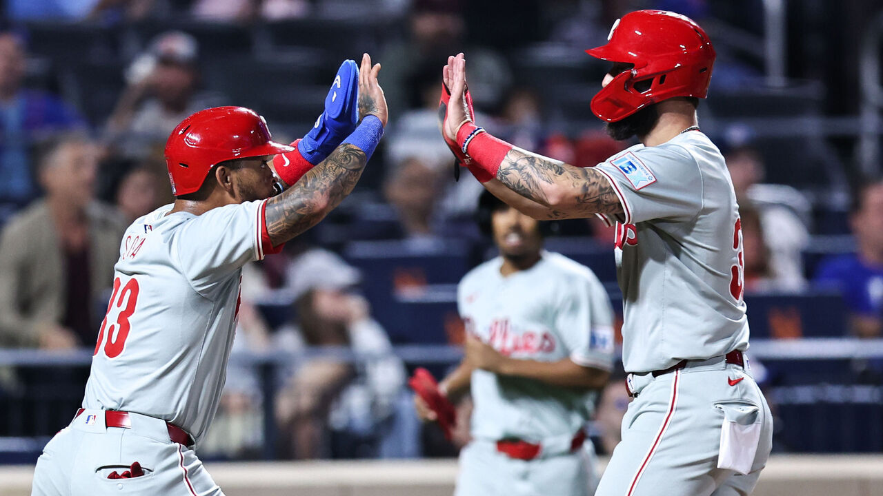 NEW YORK, NEW YORK - SEPTEMBER 20: (L-R) Edmundo Sosa #33 and Weston Wilson #37 of the Philadelphia Phillies high five after scoring during the fourth inning of the game against the New York Mets at Citi Field on September 20, 2024 in New York City.