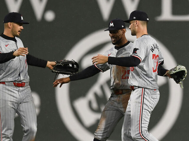BOSTON, MASSACHUSETTS - SEPTEMBER 20: (L-R) Trevor Larnach #9 of the Minnesota Twins, Byron Buxton #25, and Matt Wallner #38 embrace after their twelfth inning win over the Boston Red Sox at Fenway Park on September 20, 2024 in Boston, Massachusetts.