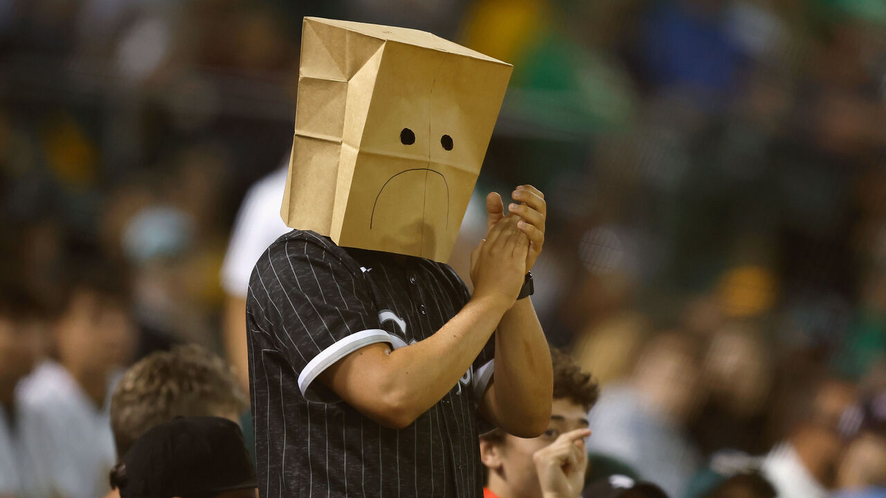 OAKLAND, CALIFORNIA - AUGUST 06: A spectator wearing a paper bag on their head claps after the Chicago White Sox record an out in the bottom of the eighth inning against the Oakland Athletics at Oakland Coliseum on August 06, 2024 in Oakland, California.