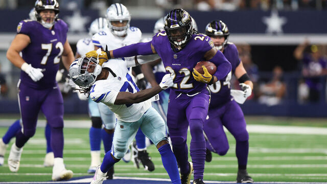 ARLINGTON, TEXAS - SEPTEMBER 22: Derrick Henry #22 of the Baltimore Ravens rushes for a first down against Caelen Carson #21 of the Dallas Cowboys during the third quarter at AT&T Stadium on September 22, 2024 in Arlington, Texas.