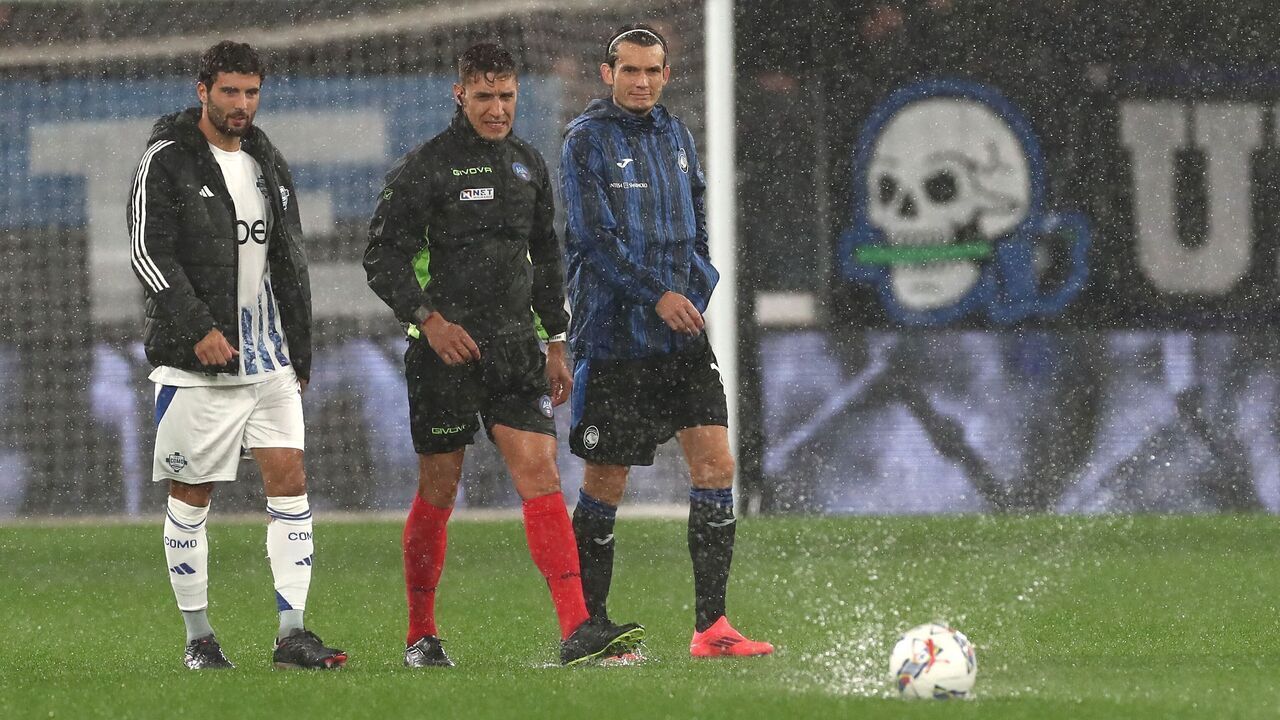 BERGAMO, ITALY - SEPTEMBER 23: Referee Fabiano Preti, Marten De Roon captain of Atalanta BC and Patrick Cutrone captain of Como 1907 inspect the pitch under heavy rain before the start of the Serie A match between Atalanta BC and Como 1907 at Gewiss Stadium on September 23, 2024 in Bergamo, Italy.