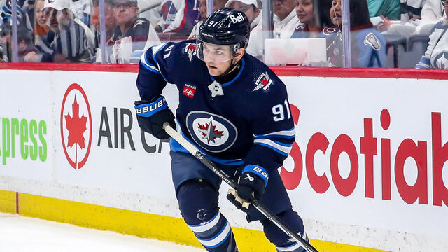 WINNIPEG, CANADA - APRIL 30: Cole Perfetti #91 of the Winnipeg Jets plays the puck along the boards during first period action against the Colorado Avalanche in Game Five of the First Round of the 2024 Stanley Cup Playoffs at the Canada Life Centre on April 30, 2024 in Winnipeg, Manitoba, Canada. The Avs defeated the Jets 6-3 and win the series 4-1.