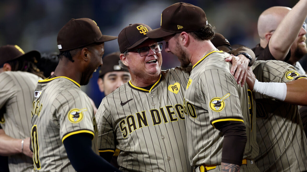 LOS ANGELES, CALIFORNIA - SEPTEMBER 24: Jurickson Profar #10, Manager Mike Shildt #8 and Jackson Merrill #3 of the San Diego Padres celebrate after the 4-2 win against the Los Angeles Dodgers to clinch a playoff spot at Dodger Stadium on September 24, 2024 in Los Angeles, California.