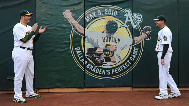 Oakland Athletics catcher Landon Powell congratulates teammate Dallas Braden after unveiling a logo in left field during a pre-game ceremony honoring Braden before the Oakland Athletics vs. San Francisco Giants game on Friday, May 21, 2010 at Oakland-Alameda County Coliseum in Oakland, Calif. Braden tossed the 19th Perfect Game in major league baseball history on May 9, 2010 against the Tampa Bay Rays. The only other pitcher for the Oakland Athletics to throw a perfect game was Catfish Hunter on May 8, 1968, against the Minnesota Twins. (Jose Carlos Fajardo/Staff)