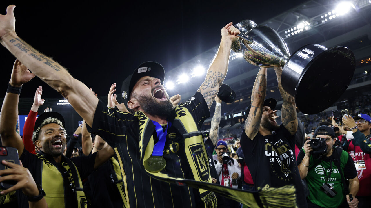 LOS ANGELES, CALIFORNIA - SEPTEMBER 25: Olivier Giroud #9 of Los Angeles FC hoisting the championship trophy celebrates with teammate as fans after defeating Sporting Kansas City, 3-1, in extra time during the U.S. Open Cup Championship match between Sporting Kansas City and Los Angeles Football Club at BMO Stadium on September 25, 2024 in Los Angeles, California.