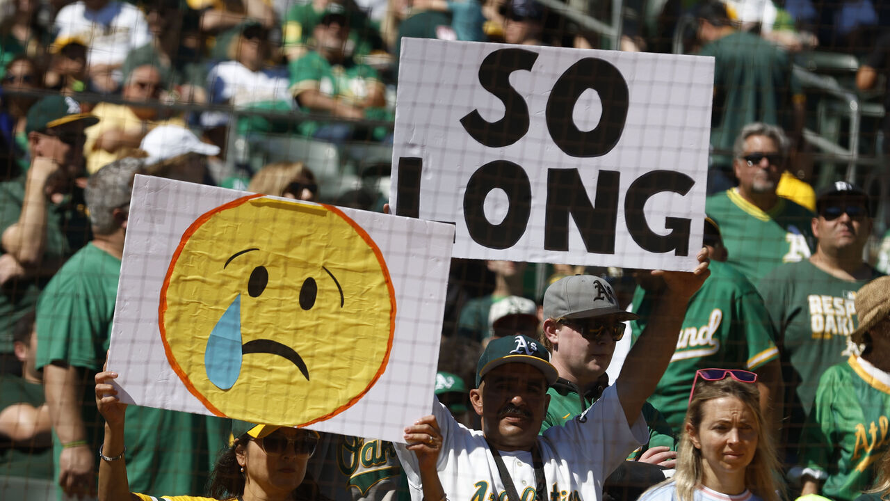 OAKLAND, CA - SEPTEMBER 26: Fans hold up signs prior to the game between the Texas Rangers and the Oakland Athletics at RingCentral Coliseum on Thursday, September 26, 2024 in Oakland, California.