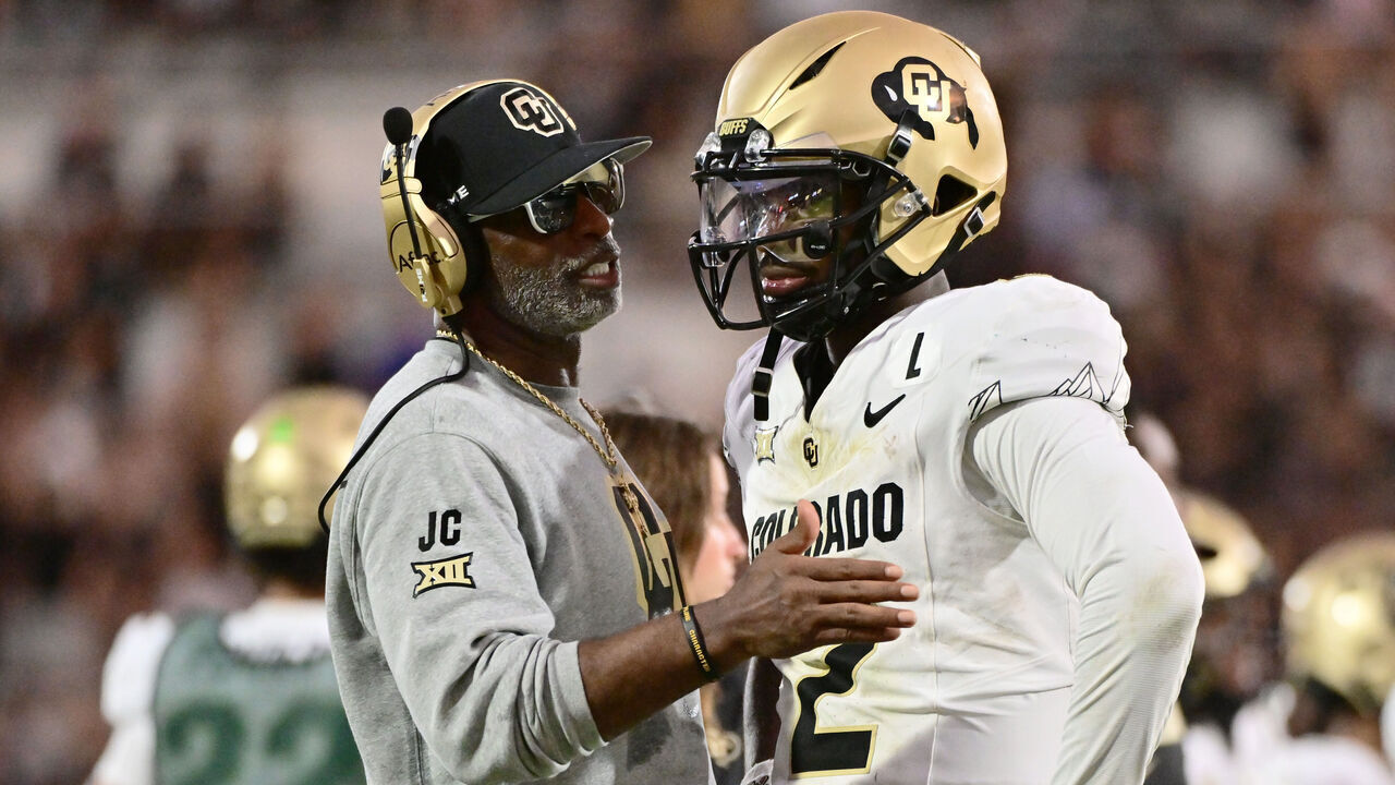 ORLANDO, FLORIDA - SEPTEMBER 28: Head coach Deion Sanders of the Colorado Buffaloes talks with Shedeur Sanders #2 during the second half of a game against the UCF Knights at FBC Mortgage Stadium on September 28, 2024 in Orlando, Florida.