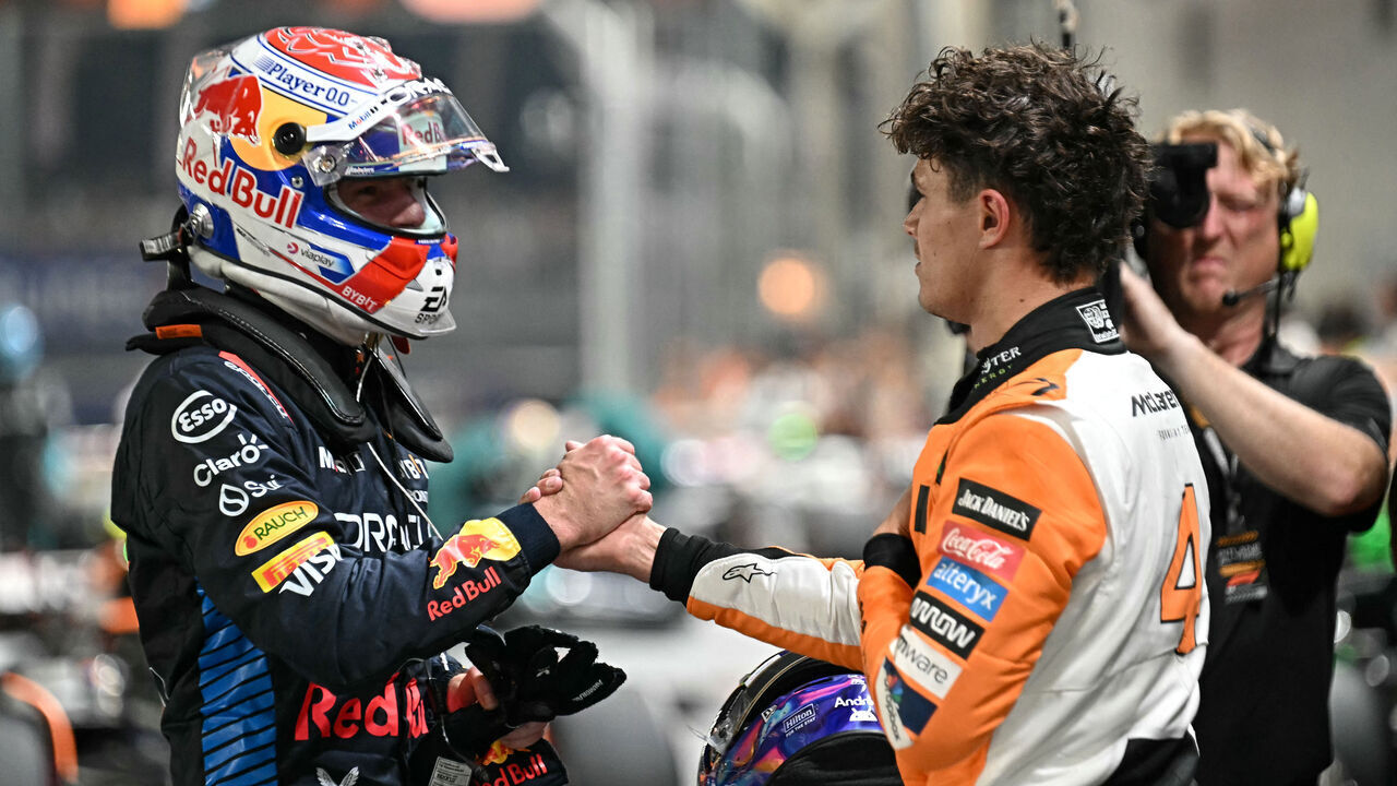 McLaren's British driver Lando Norris (R), who got pole position, greets Red Bull Racing's Dutch driver Max Verstappen who got second position after the qualifying session ahead of the Formula One Singapore Grand Prix night race at the Marina Bay Street Circuit in Singapore on September 21, 2024.