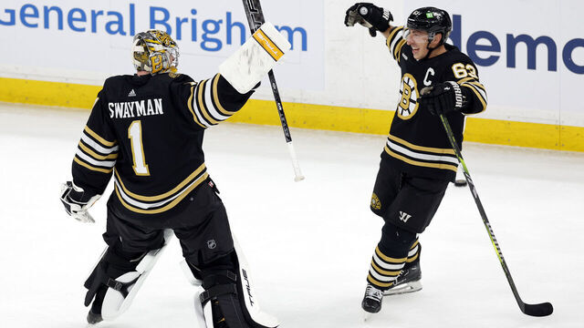 Boston, MA - February 19: Boston Bruins goaltender Jeremy Swayman and left wing Brad Marchand react after the game. The Bruins beat the Dallas Stars, 4-3.