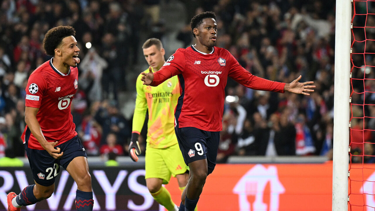 LILLE, FRANCE - OCTOBER 02: Jonathan David of LOSC Lille celebrates scoring his team's first goal from the penalty spot with teammate Tiago Santos during the UEFA Champions League 2024/25 League Phase MD2 match between LOSC Lille and Real Madrid C.F. at Stade Pierre Mauroy on October 02, 2024 in Lille, France.