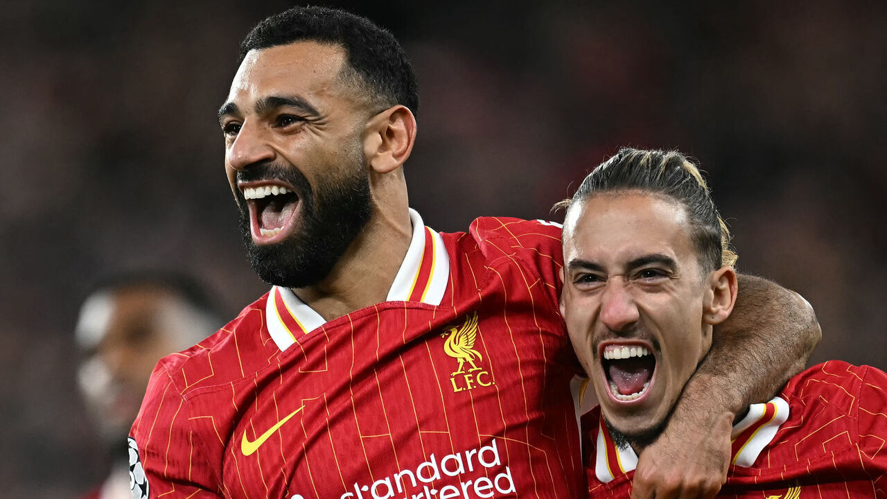 Liverpool's Egyptian striker #11 Mohamed Salah celebrates scoring the team's second goal with Liverpool's Greek defender #21 Kostas Tsimikas during the UEFA Champions League league stage football match between Liverpool and Bologna at Anfield in Liverpool, north west England on October 2, 2024.