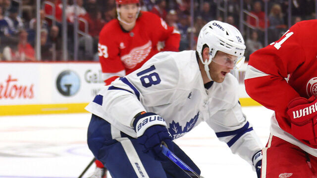 DETROIT, MICHIGAN - OCTOBER 03: Dylan Larkin #71 of the Detroit Red Wings controls the puck in front of Steven Lorentz of the Toronto Maple Leafsduring a pre season game at Little Caesars Arena on October 03, 2024 in Detroit, Michigan.