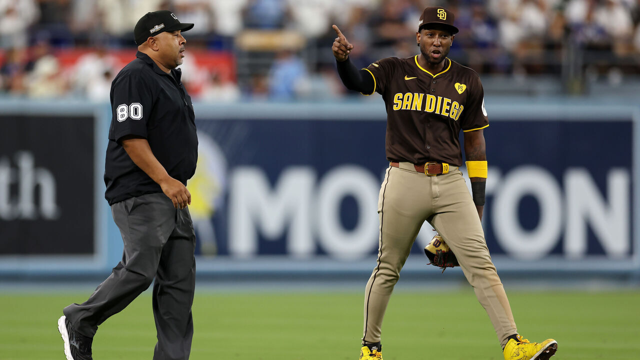 LOS ANGELES, CALIFORNIA - OCTOBER 06: Jurickson Profar #10 of the San Diego Padres walks across the field escorted by an umpire in the seventh inning against the Los Angeles Dodgers during Game Two of the Division Series at Dodger Stadium on October 06, 2024 in Los Angeles, California.