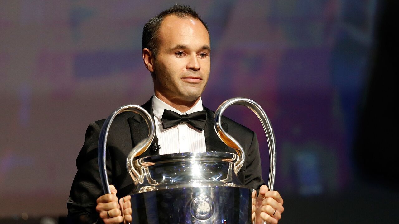 FC Barcelona's captain Andres Iniesta holds the Champions League trophy at the start of the UEFA Champions League Group stage draw ceremony, on August 27, 2015 in Monaco. AFP PHOTO / VALERY HACHE