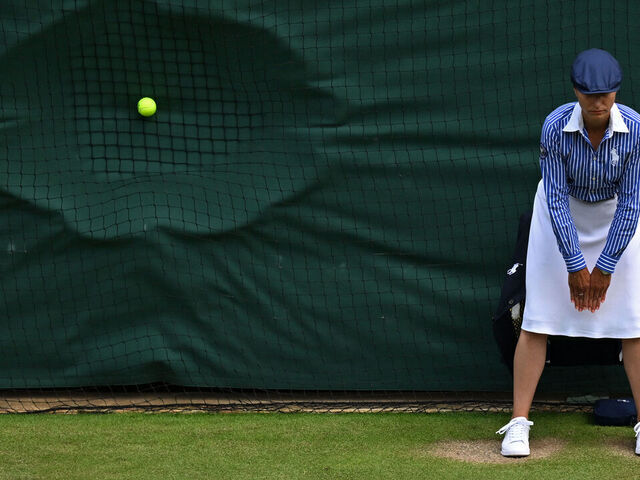 TOPSHOT - A line judge stands in position as a ball hits the back netting after a serve during the men's doubles semi-final tennis match between Britain's Henry Patten and Finland's Harri Heliövaara, and New Zealand's Michael Venus and Britain's Neal Skupski, on the eleventh day of the 2024 Wimbledon Championships at The All England Lawn Tennis and Croquet Club in Wimbledon, southwest London, on July 11, 2024.