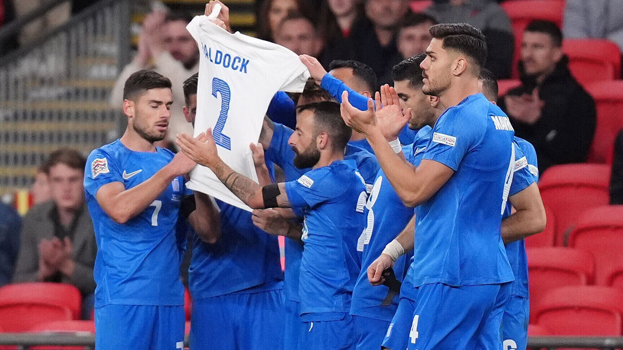 Greece players hold aloft a shirt in memory of George Baldock after Evangelos Pavlidis scores the opening goal of the game during the UEFA Nations League Group B2 match at Wembley Stadium, London. Picture date: Thursday October 10, 2024.