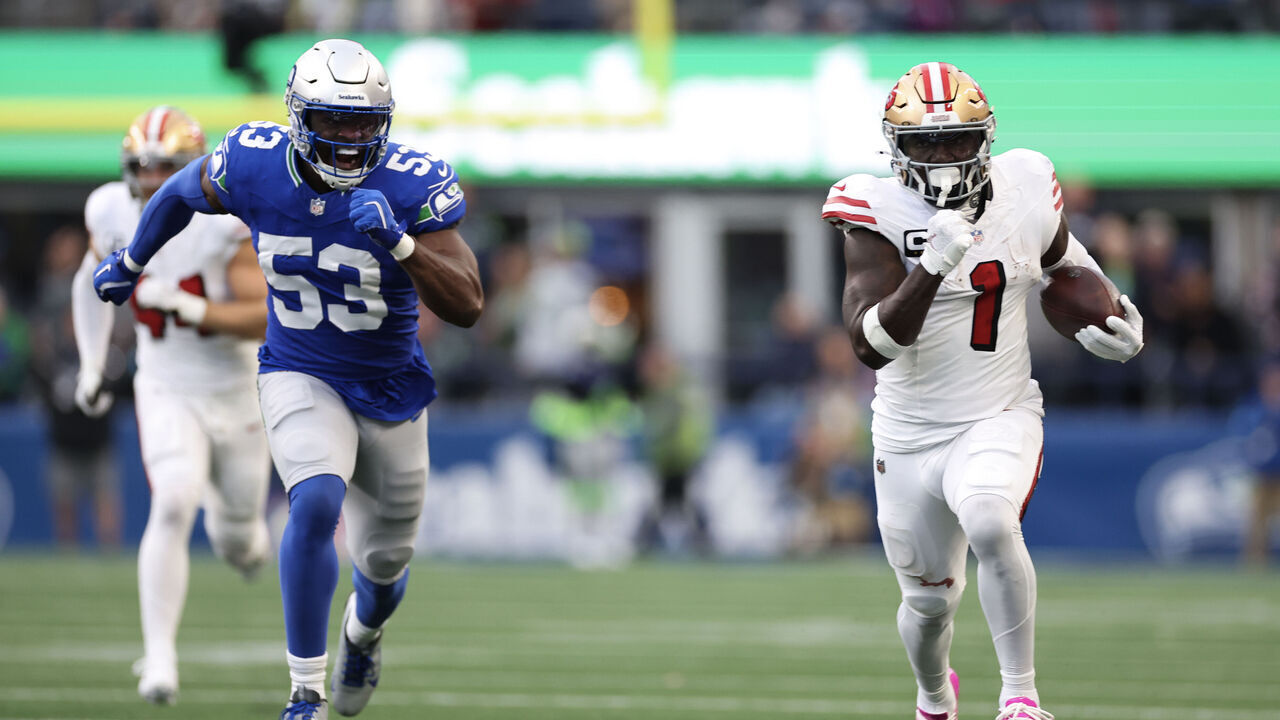 SEATTLE, WASHINGTON - OCTOBER 10: Deebo Samuel Sr. #1 of the San Francisco 49ers runs the ball for a touchdown ahead of Boye Mafe #53 of the Seattle Seahawks during the second quarter at Lumen Field on October 10, 2024 in Seattle, Washington.