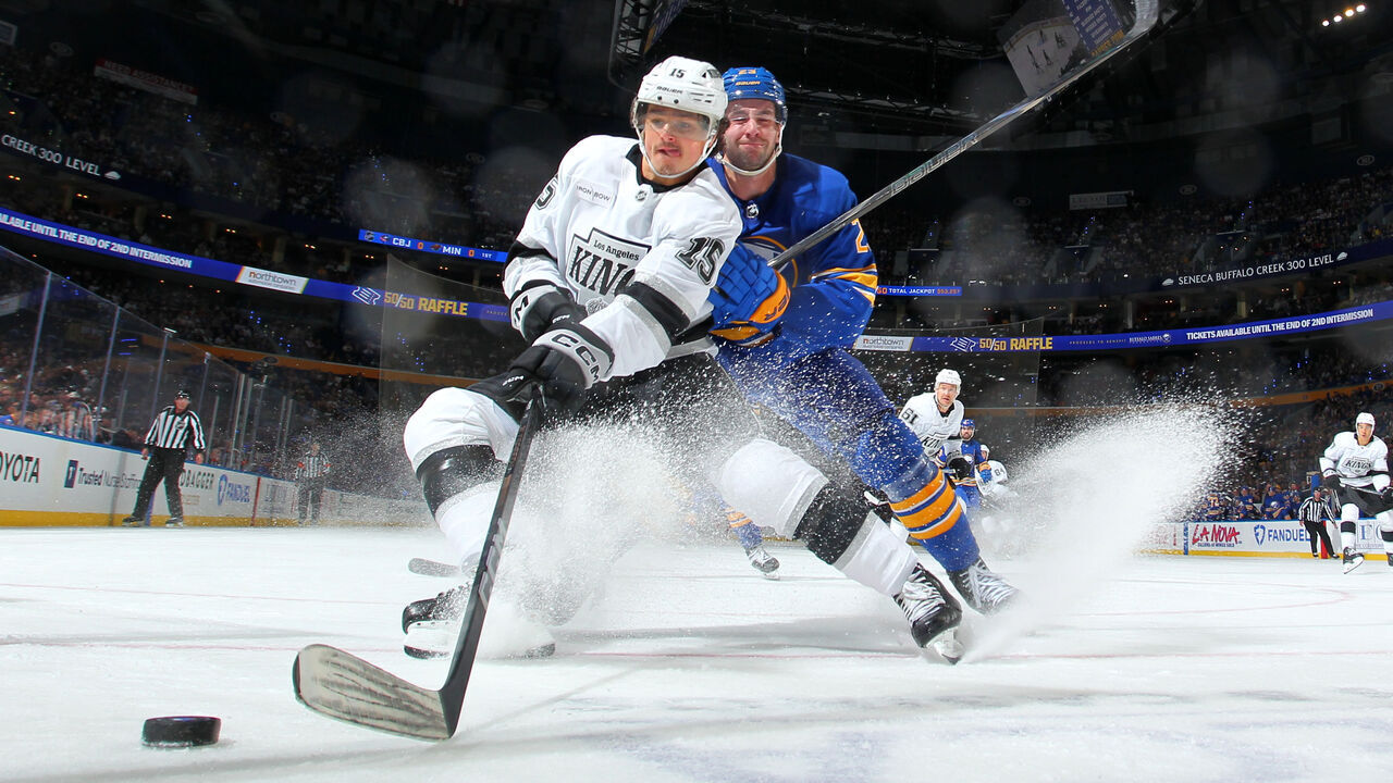 BUFFALO, NEW YORK - OCTOBER 10: Alex Turcotte #15 of the Los Angeles Kings looks to control the puck against Mattias Samuelsson #23 of the Buffalo Sabres during an NHL game on October 10, 2024 at KeyBank Center in Buffalo, New York.