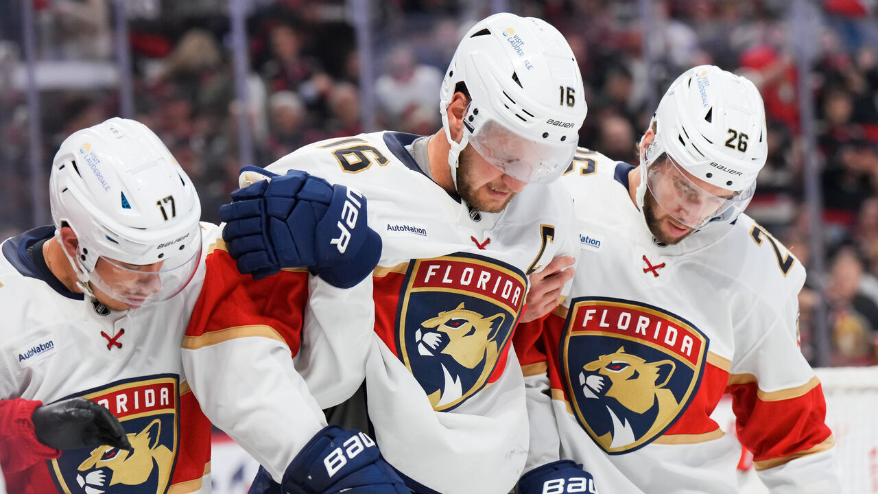 OTTAWA, CANADA - OCTOBER 10: Aleksander Barkov #16 of the Florida Panthers is helped off the ice by teammates Evan Rodrigues #17 and Uvis Balinskis #26 after colliding with the boards during the third period at Canadian Tire Centre on October 10, 2024 in Ottawa, Ontario, Canada.