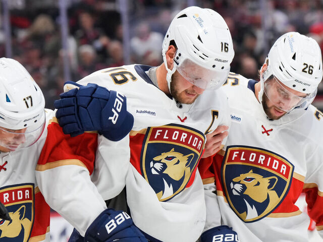OTTAWA, CANADA - OCTOBER 10: Aleksander Barkov #16 of the Florida Panthers is helped off the ice by teammates Evan Rodrigues #17 and Uvis Balinskis #26 after colliding with the boards during the third period at Canadian Tire Centre on October 10, 2024 in Ottawa, Ontario, Canada.