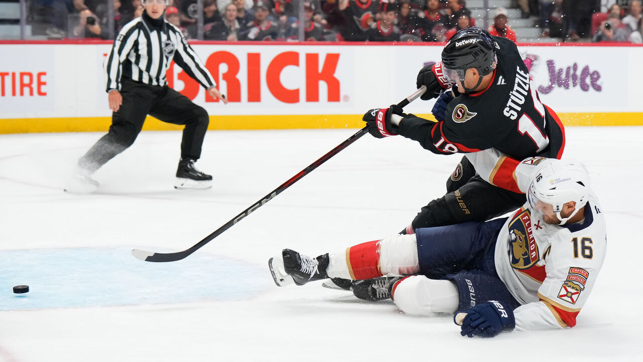OTTAWA, CANADA - OCTOBER 10: Tim Stützle #18 of the Ottawa Senators scores a third period empty net goal as he battles with Aleksander Barkov #16 of the Florida Panthers at Canadian Tire Centre on October 10, 2024 in Ottawa, Ontario, Canada.