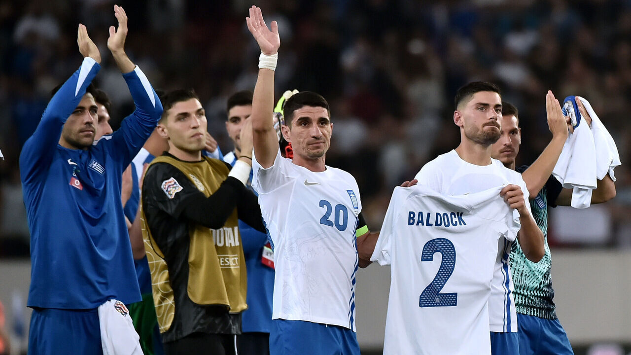 PIRAEUS, GREECE - OCTOBER 13: Giorgos Masouras of Greece is seen holding a shirt which reads 'Baldock 2' in honour of the passing of former Greek football player George Baldock, as teammates acknowledge the fans after the team's victory during the UEFA Nations League 2024/25 League B Group B2 match between Greece and Republic of Ireland at Stadio Georgios Karaiskakis on October 13, 2024 in Piraeus, Greece.