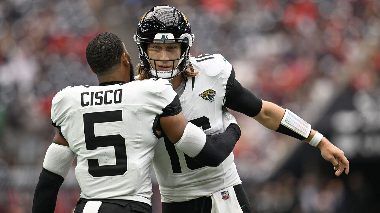 HOUSTON, TEXAS - SEPTEMBER 29: Trevor Lawrence #16 of the Jacksonville Jaguars and Andre Cisco #5 embrace prior to the game against the Houston Texans at NRG Stadium on September 29, 2024 in Houston, Texas.