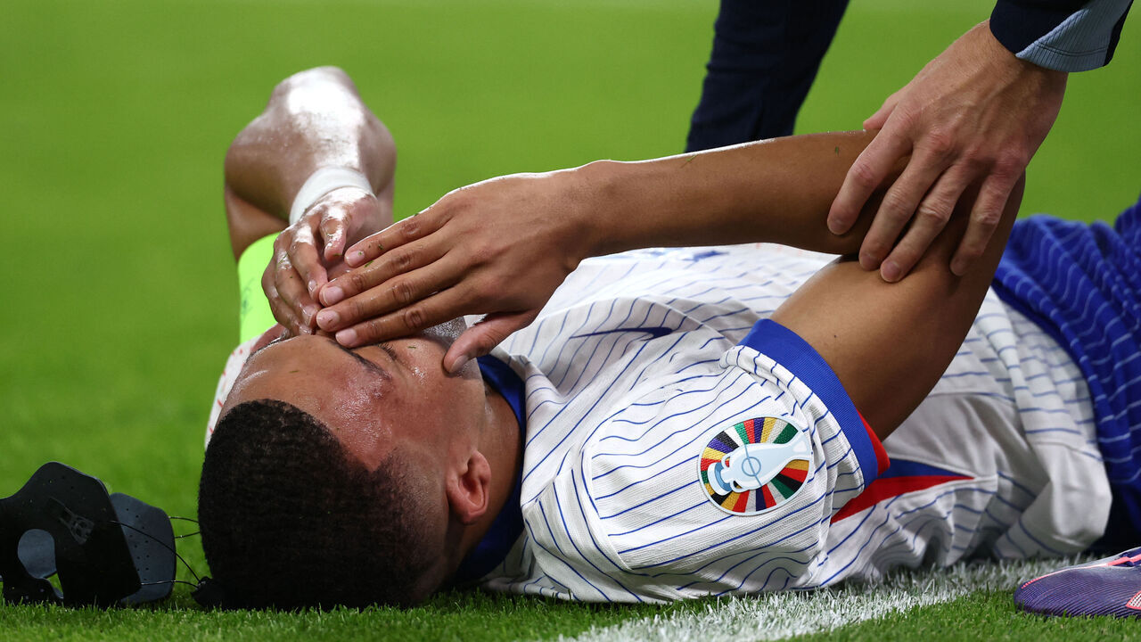 TOPSHOT - France's forward #10 Kylian Mbappe receives medical attention following an injury during the UEFA Euro 2024 quarter-final football match between Portugal and France at the Volksparkstadion in Hamburg on July 5, 2024.