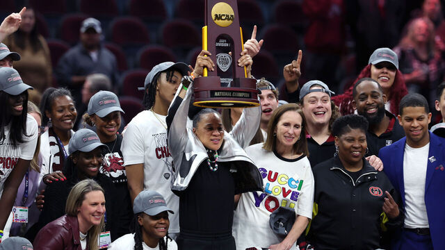 CLEVELAND, OHIO - APRIL 07: Head coach Dawn Staley of the South Carolina Gamecocks hoists the trophy after beating the Iowa Hawkeyes in the 2024 NCAA Women's Basketball Tournament National Championship at Rocket Mortgage FieldHouse on April 07, 2024 in Cleveland, Ohio. South Carolina beat Iowa 87-75.