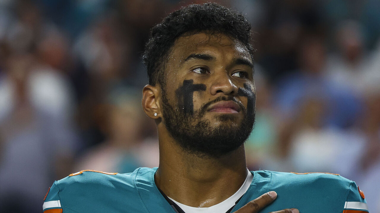 MIAMI GARDENS, FL - SEPTEMBER 12: Tua Tagovailoa #1 of the Miami Dolphins looks on from the sideline during the national anthem prior to an NFL football game against the Buffalo Bills at Hard Rock Stadium on September 12, 2024 in Miami Gardens, FL.