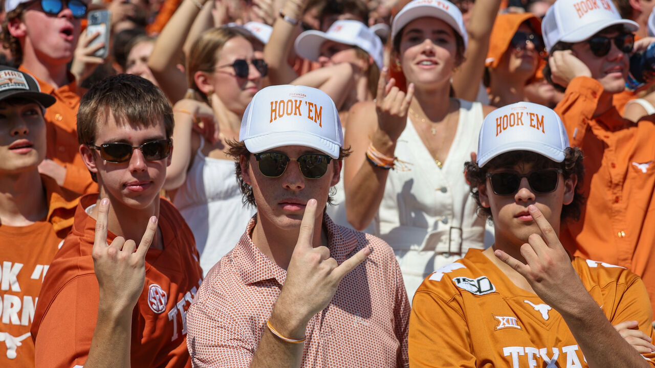 DALLAS, TX - OCTOBER 12: Student fans where Hook 'Em hats while they hold up the Hook 'Em Horns sign before the Allstate Red River Rivalry SEC college football game between Texas Longhorns and Oklahoma Sooners on October 12, 2024, at Cotton Bowl Stadium in Dallas, TX.