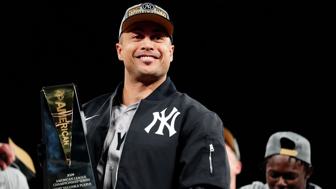CLEVELAND, OH - OCTOBER 19: Giancarlo Stanton #27 of the New York Yankees poses with the 2024 ALCS MVP Award after the Yankees defeated the Cleveland Guardians in Game 5 of the ALCS presented by loanDepot at Progressive Field on Saturday, October 19, 2024 in Cleveland, Ohio.