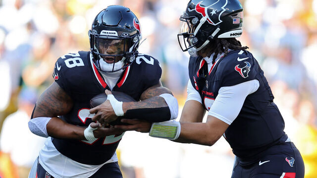 GREEN BAY, WISCONSIN - OCTOBER 20: C.J. Stroud #7 hands the ball off to Joe Mixon #28 of the Houston Texans during the second quarter against the Green Bay Packers at Lambeau Field on October 20, 2024 in Green Bay, Wisconsin.