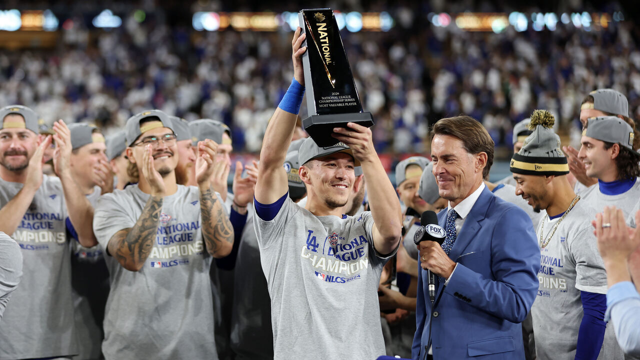 LOS ANGELES, CALIFORNIA - OCTOBER 20: Tommy Edman #25 of the Los Angeles Dodgers hoists the MVP trophy after the Dodgers defeated the New York Mets to win Game Six of the National League Championship Series at Dodger Stadium on October 20, 2024 in Los Angeles, California.