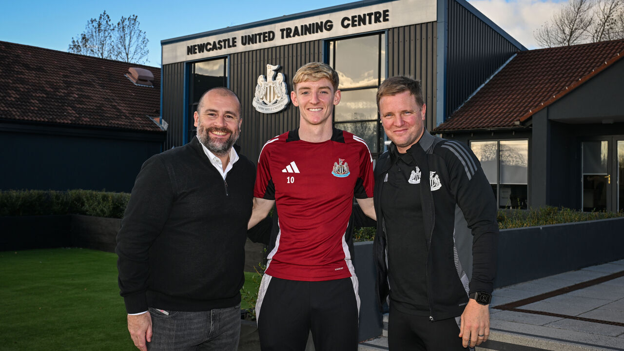 NEWCASTLE UPON TYNE, ENGLAND - OCTOBER 22: Anthony Gordon of Newcastle United (C) poses for a photo with Newcastle United Sporting Director Paul Mitchell (L) and Newcastle United Head Coach Eddie Howe (R) after signing a long term contract on October 22, 2024 in Newcastle upon Tyne, England.