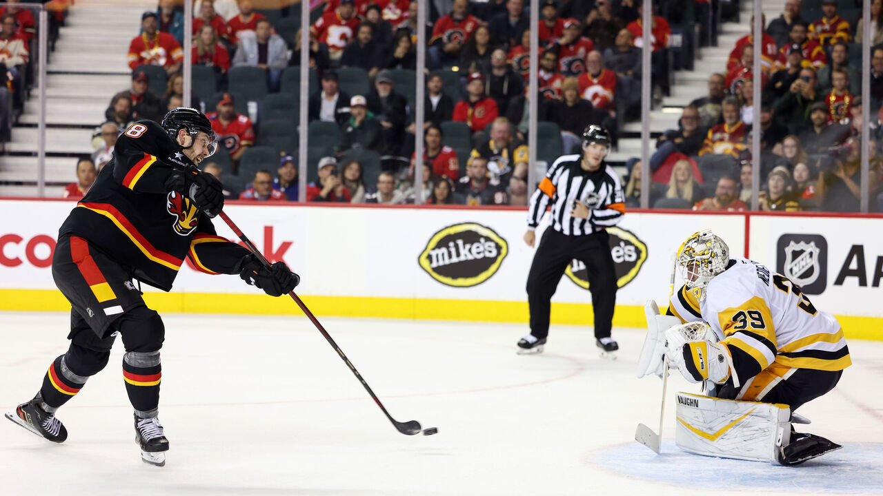 CALGARY, CANADA - OCTOBER 22: Justin Kirkland #58 of the Calgary Flames scores the winning shoot-out goal on Alex Nedeljkovic #39 of the Pittsburgh Penguins at the Scotiabank Saddledome on October 22, 2024 in Calgary, Alberta, Canada.