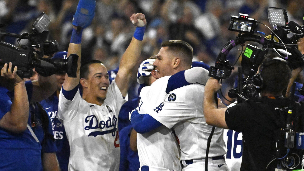 Los Angeles, CA - October 25: Freddie Freeman (5) of the Los Angeles Dodgers is mobbed by teammates after hitting a walk off grand slam in the tenth inning to defeat the New York Yankees 6-3 and win Game 1 of a World Series baseball game at Dodger Stadium in Los Angeles on Friday, October 25, 2024.