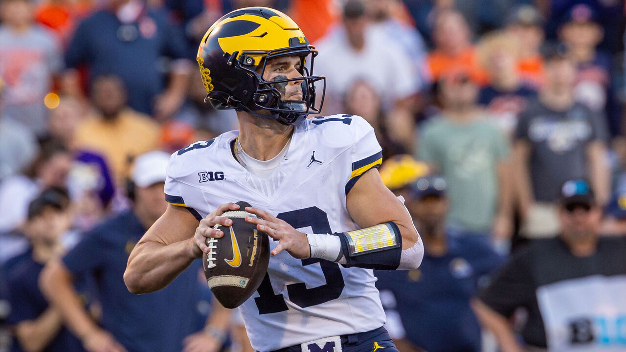 CHAMPAIGN, ILLINOIS - OCTOBER 19: Jack Tuttle #13 of the Michigan Wolverines looks to throws the ball during the game against the Illinois Fighting Illini at Memorial Stadium on October 19, 2024 in Champaign, Illinois.