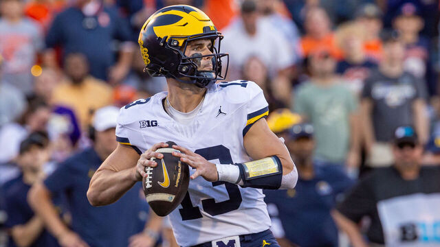 CHAMPAIGN, ILLINOIS - OCTOBER 19: Jack Tuttle #13 of the Michigan Wolverines looks to throws the ball during the game against the Illinois Fighting Illini at Memorial Stadium on October 19, 2024 in Champaign, Illinois.
