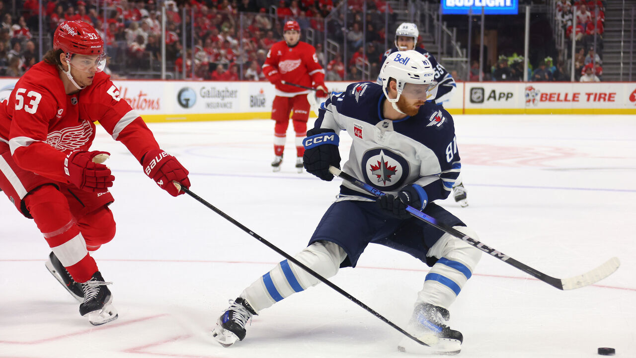 DETROIT, MICHIGAN - OCTOBER 30: Kyle Connor #81 of the Winnipeg Jets turns away from the stick of Moritz Seider #53 of the Detroit Red Wings during the first period at Little Caesars Arena on October 30, 2024 in Detroit, Michigan.